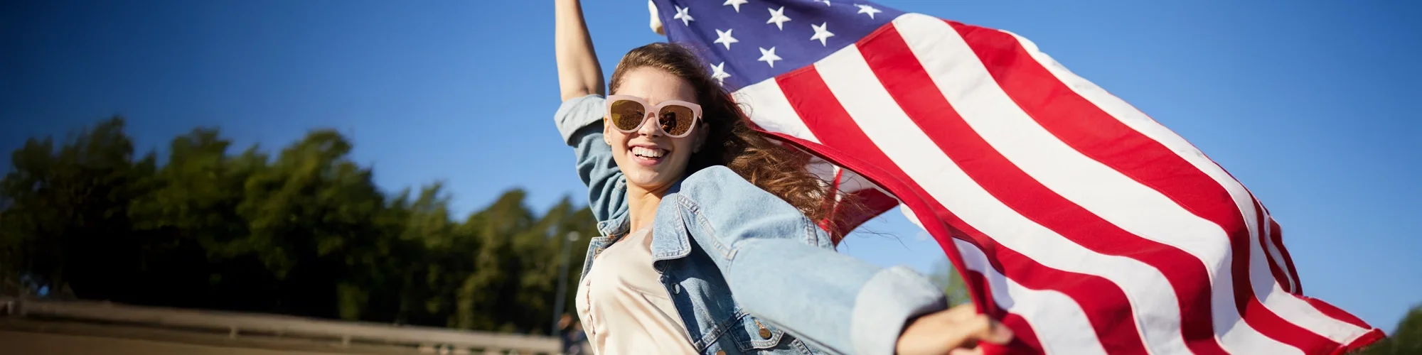 jeune fille joyeuse avec un drapeau americain au vent